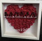 Preview: Personalisierter 3D Rosenrahmen Herz mit Kunstrosen, personalisiert mit dem Text „Mama, wir lieben dich“, ideal als Muttertagsgeschenk, aus hochwertigem Holz und Acrylglas, mit realistischen Kunstrosen in Herzform und 3D-Effekt.